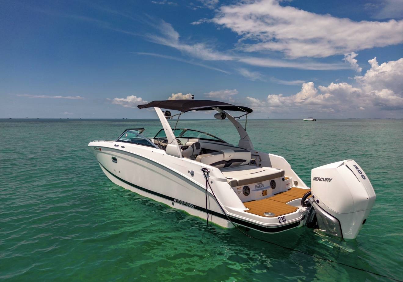 Four Winns 28 day boat at anchor over shallow turquoise water
