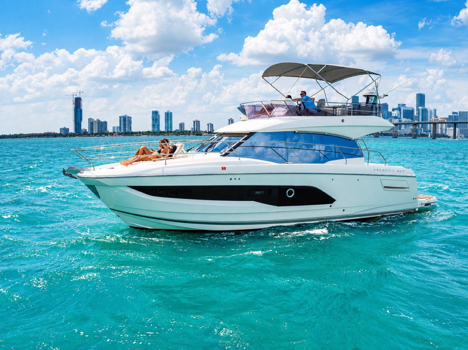 Flybridge yacht anchored in turquoise water with the Miami skyline behind, set for a birthday party