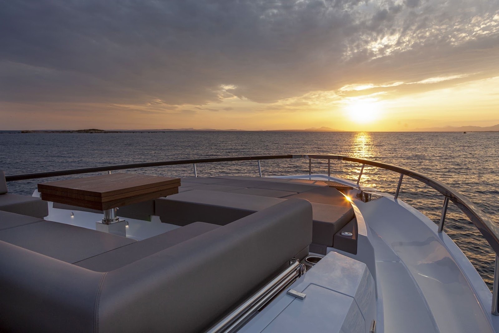 Astondoa 85 deck lounge facing the sunset on a private yacht cruise