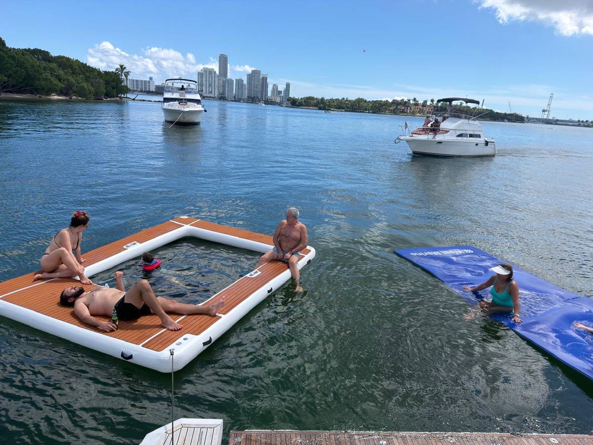 Guests on the floating pool and water mat beside the Azimut 70 "Le Grand Bleu"