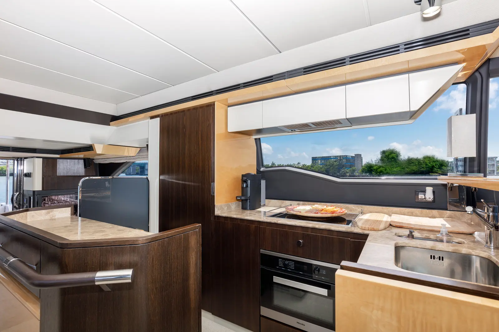 Azimut 68 "Le Grand Bleu" galley with dark wood and stone counters